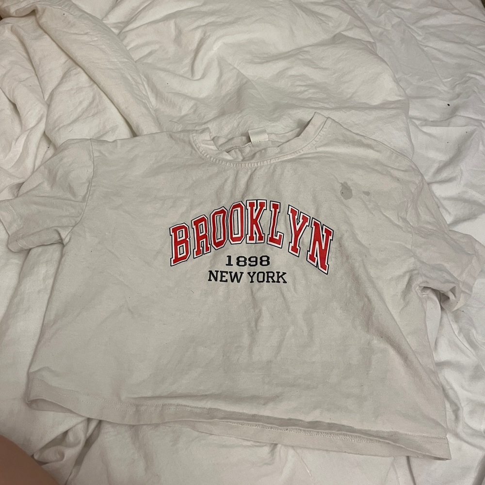 I am selling a white short sleeve crop top that says “Brooklyn 1898 New York”
